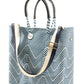 Blue and white chevron woven bucket bag made from recycled plastics featuring navy blue leather handles and a silver Coba medallion with option woven strap added