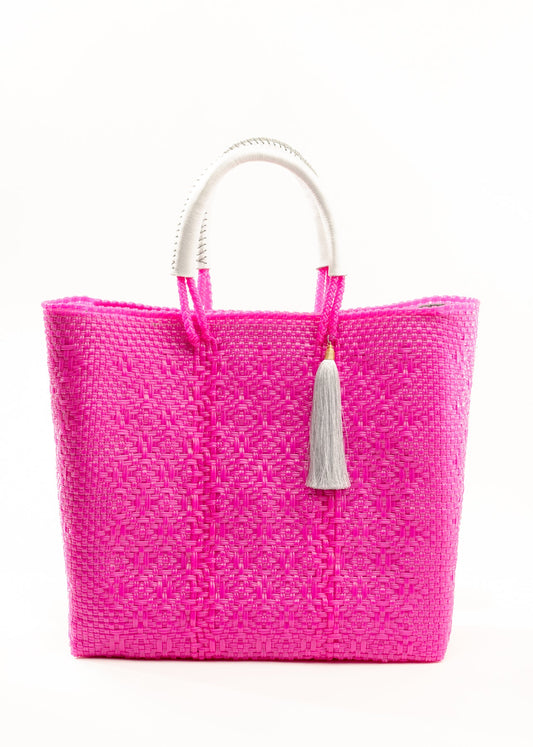 Hot pink woven bucket bag made from recycled plastics featuring a white leather handle and white tassel detail