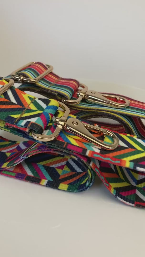 Two multi color purse straps in a row