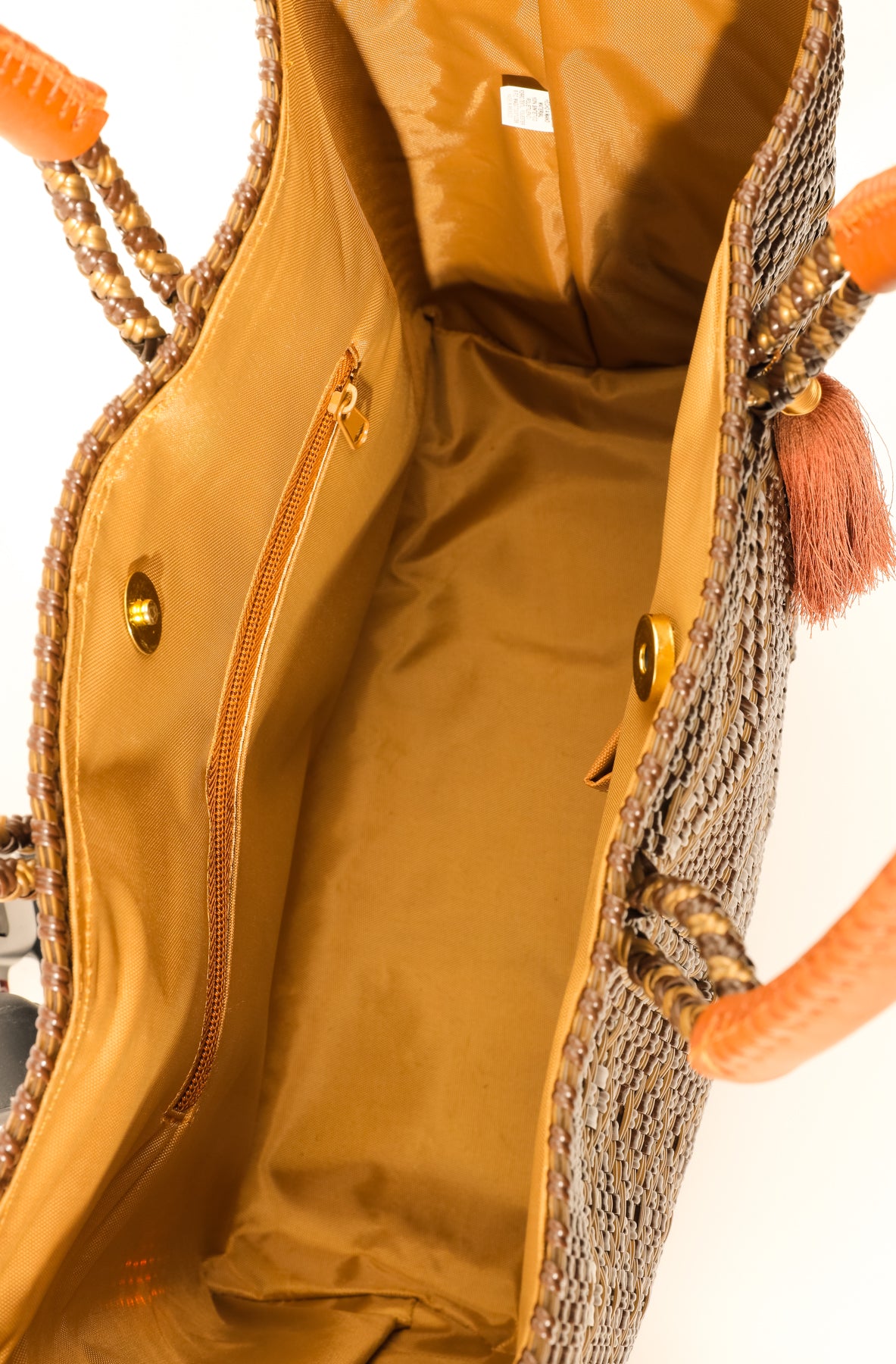 Inside tan lining with zipper pocket and magnetic closure of brown and tan chevron woven bucket bag made from recycled plastics